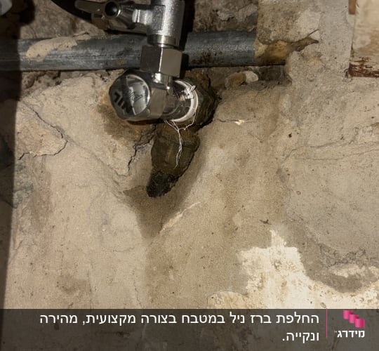 צנרת מתכת עם ברז על קיר בטון